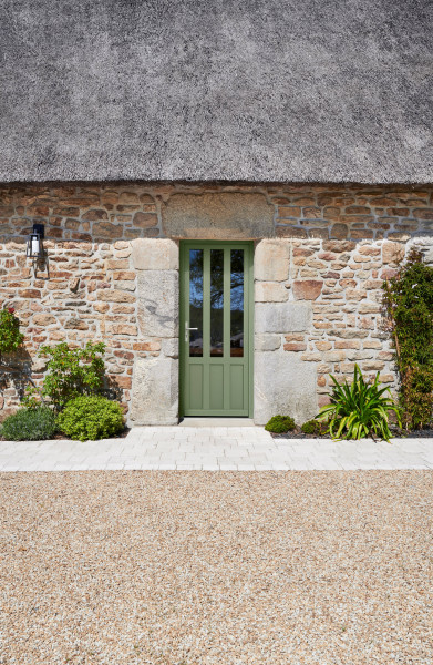 Porte d'entrée bois INDUS 2 - Visuel d'ambiance Maison traditionnelle en pierres vue extérieur avec porte d'entrée couleur verte